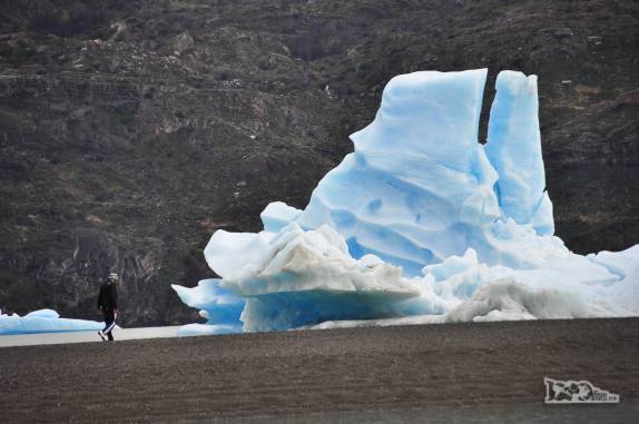 Um turista se aproxima de iceberg em praia do lago Grey, no parque Nacional Torres del Paine, no sul do Chile